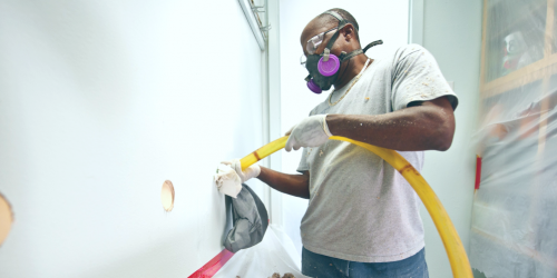 man installing wall insulation